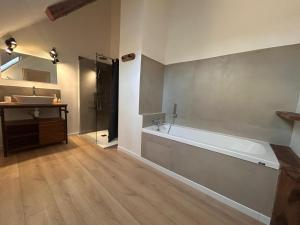 Un baño con bañera, lavabo y ducha. en Loft Ô Faix, en Ancelle 27 fotos más