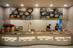 a restaurant with two people preparing food at a counter at Seabed Grand Hotel Phuket in Phuket +166 photos