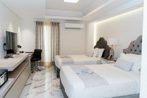 a hotel room with two beds and a desk at The Residence by Ivory in Iligan City +27 photos