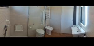 a white bathroom with a toilet and a sink at Holiday Rooms in Santa Teresa in Santa Teresa Gallura