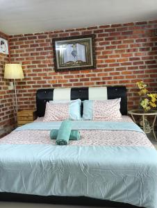 a bedroom with a large bed with a brick wall at Villa Mas GentingMuslim Homestay in Yan