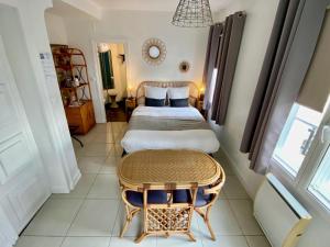 a hotel room with two beds and a table at Les Rives du Cher - Chambres d'hôtes in Montrichard