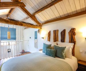 a bedroom with a large bed with wooden beams at Ostalon de Sénégats in Lacaze