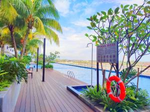 una pasarela de madera junto a una piscina con un salvavidas en ABHOME "TITIANIC SUITE" Midas Seri Alam #Mall #Masai JB, en Masai