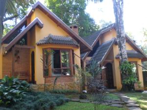 una casa amarilla con en Pousada Solar das Montanhas en Penedo