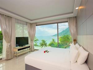 a bedroom with a large bed and a large window at Oh La La Koh Phangan in Haad Rin