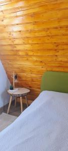 a bedroom with a bed and a wooden wall at Cabana Alive - Colibita in Colibiţa