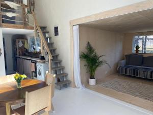 a living room with a dining room table and a loft bed at JES Kalana Beachhouse in Kalana