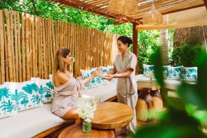 two women are sitting on a couch talking at Zazen Boutique Resort & Spa in Bophut