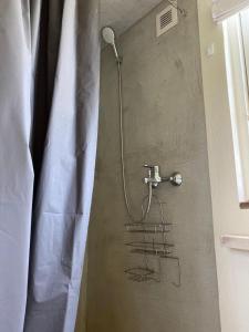 a shower with a shower head and a shower curtain at JES Kalana Beachhouse in Kalana +22 photos