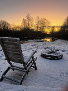 a wooden rocking chair sitting in the snow at Auszeit im Grünen in Fårvang
