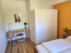 a bedroom with a bed and a table and a desk at 2-Zimmer Wohnung 2 - Apartments am Schloss in Oberschleißheim