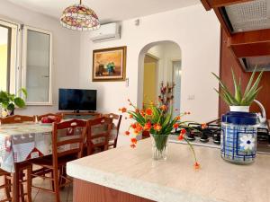 een keuken met een vaas met bloemen op een aanrecht bij Yellow Beachfront house 60 m by Salento Prime in Marina di Pescoluse