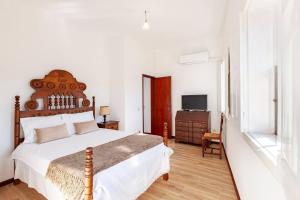 una camera da letto con un letto grande e una televisione di Casa da Avó Zilda a Guimarães