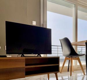 a living room with a flat screen tv and a chair at Villa Athina 1 in Serres