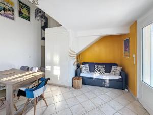 ein Wohnzimmer mit einem blauen Sofa und einem Tisch in der Unterkunft Villa for 6 people with WiFi, parking, and garden in Saint-Raphaël