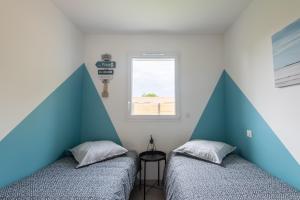 two beds in a room with blue and white walls at Bleu cargo in Biscarrosse