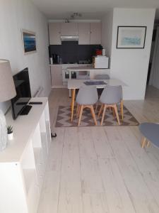 a kitchen with a table and two chairs and a counter at Marco Polo in Les Sables-d'Olonne +5 photos