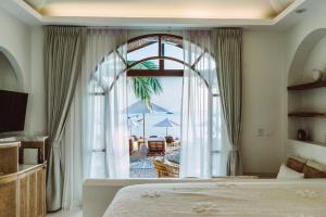 a bedroom with a bed and a view of a beach at Zazen Boutique Resort & Spa in Bophut