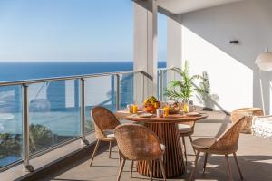 a table and chairs on a balcony with a view of the ocean at OurMadeira - Palace Ocean View in Funchal