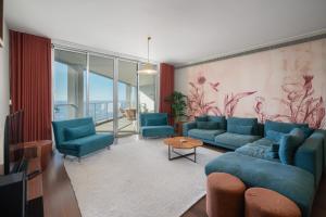 a living room with a blue couch and chairs at OurMadeira - Palace Ocean View in Funchal