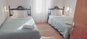 two twin beds in a room with a door at Casa Filo - Country house near la Cruz de Piedra in Plasenzuela +47 photos