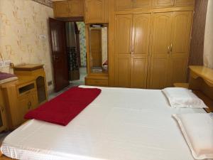a large white bed with a red towel on it at Shahgul's Service Apartments in Hyderabad +2 photos