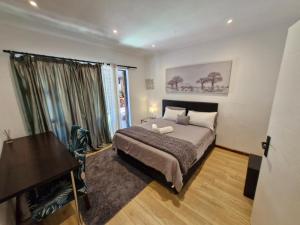 a bedroom with a bed and a desk and a piano at Regent Casa's - Cape Towns Blouberg Area - Where 20 people can stay in Cape Town +69 photos