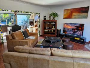 a living room with two couches and a fireplace at Regent Casa's - Cape Towns Blouberg Area - Where 20 people can stay in Cape Town