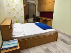 a small bedroom with a bed and a desk at Shahgul's Service Apartments in Hyderabad