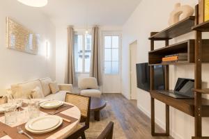 un salon avec une table et une salle à manger dans l'établissement Elégant appartement à deux pas du Moulin Rouge, à Paris