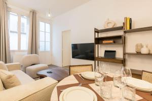 - un salon avec une table et des verres à vin dans l'établissement Elégant appartement à deux pas du Moulin Rouge, à Paris