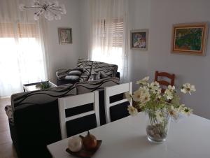 a living room with a table with a vase of flowers at Cuencaloft el patio de Pipo in Cuenca