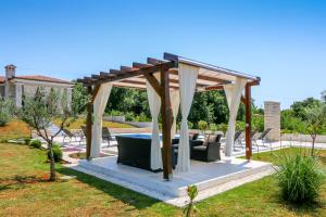 a gazebo with a table and chairs in a yard at Villa Tara in Medulin