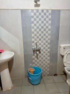 a bathroom with a sink and a toilet and a bucket at Shahgul's Service Apartments in Hyderabad