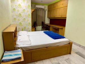 a small bedroom with a bed and a desk at Shahgul's Service Apartments in Hyderabad
