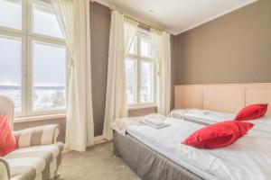 a bedroom with two beds and a couch and windows at Mukkulan kartano in Lahti