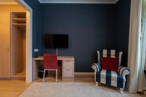 a room with a desk and two chairs and a television at Mukkulan kartano in Lahti