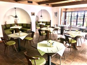 a dining room with tables and chairs and windows at Hotel Fürstenhof in Füssen