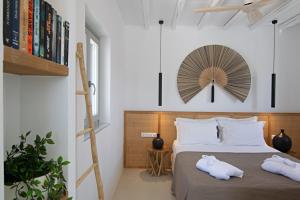 Oneiro 4BDR Villa in Antiparos Sirocco Villa في أنديباروس: غرفة نوم بها سرير عليه منشفتان +34 صورة