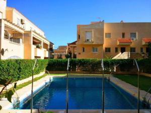 a swimming pool in front of a building at Villasara 3D Parking gratis in Aguadulce