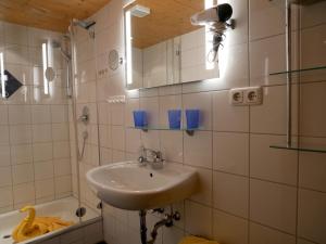 a bathroom with a sink and a mirror and a tub at Haus Edelweiß in Bad Hindelang +42 photos