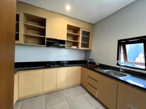 a kitchen with a sink and a window at Grand Kesambi Family Villa by Miel Property in Seminyak