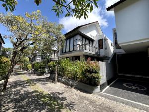 a house with a lot of plants in front of it at Grand Kesambi Family Villa by Miel Property in Seminyak