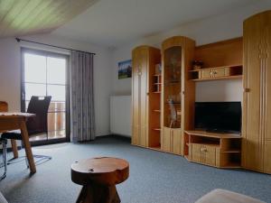 a living room with wooden furniture and a television at Haus Edelweiß in Bad Hindelang