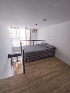 マンダウエ・シティにあるCentro City Loftのベッドと木の床のある寝室