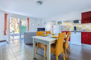 a kitchen and dining room with a table and chairs at Bastidon Provençal - Avec piscine partagée in Aubignan +5 photos