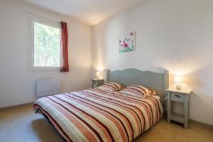 a bedroom with a bed with two tables and a window at Bastidon Provençal - Avec piscine partagée in Aubignan