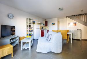 a living room with a table and a kitchen at Bastidon Provençal - Avec piscine partagée in Aubignan