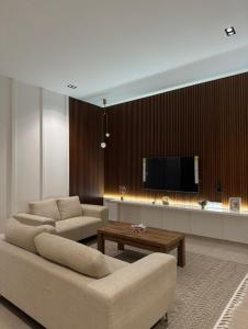 艾恩Al Ain Hotel Apartment Family Stay with Balcony and Pool Access的配有两张沙发和一台平板电视的客厅